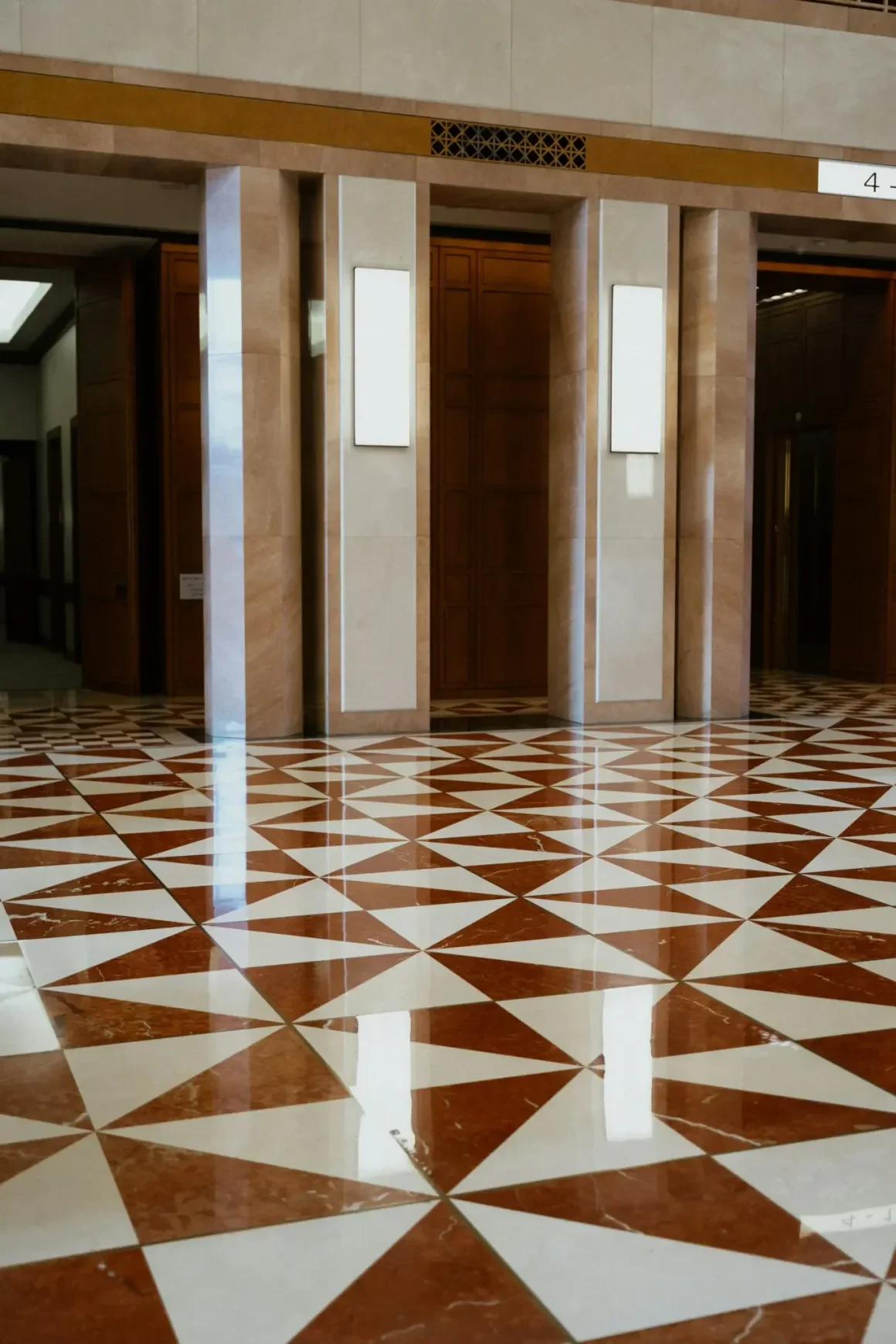 Grand building lobby with polished red and white geometric star-pattern marble floor tile